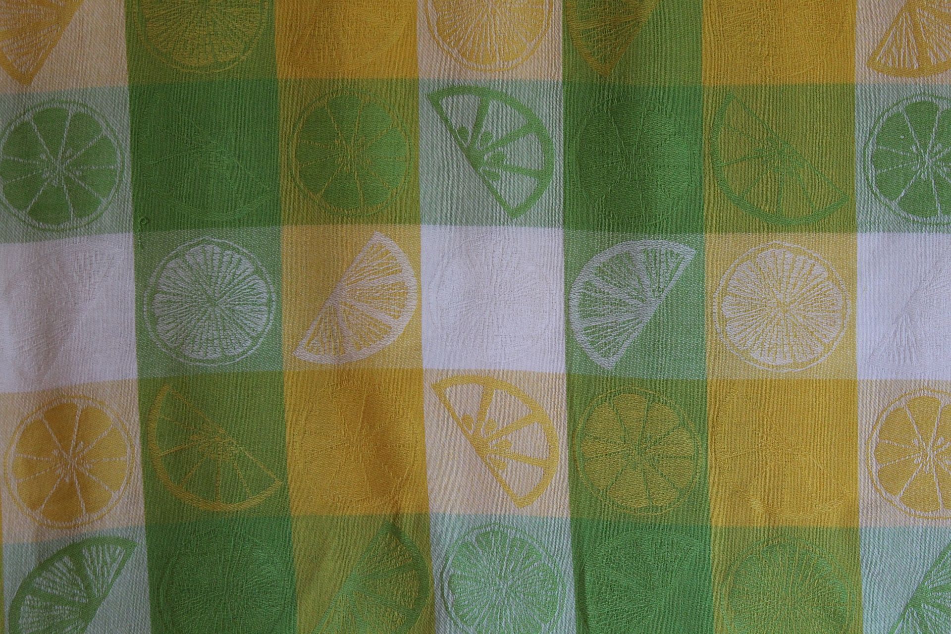 Yellow, green, and white checkered fabric with citrus slice patterns