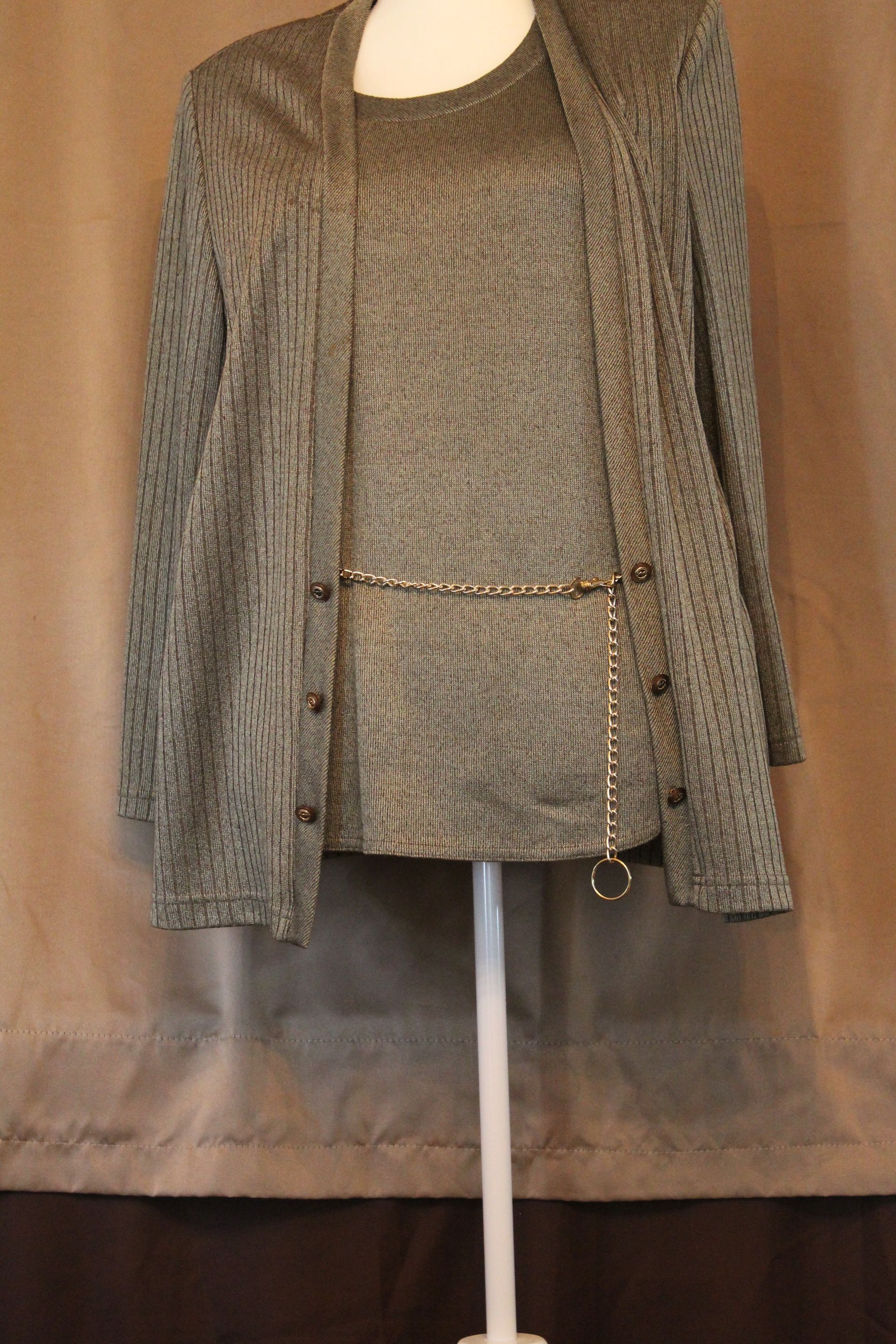 Gray patterned jacket and matching top displayed on a mannequin against a brown backdrop.