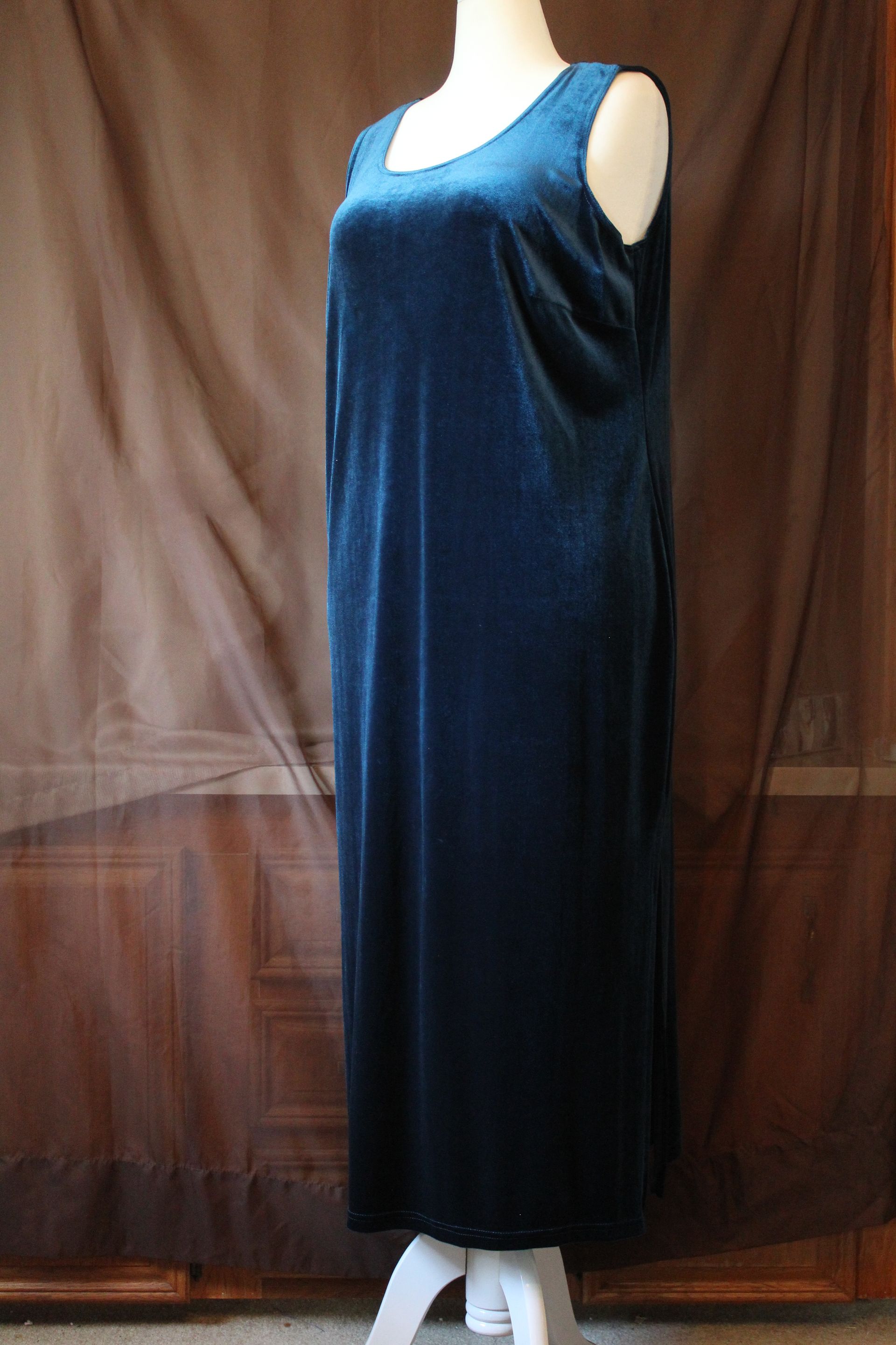Blue velvet outfit displayed on a mannequin against a tan backdrop