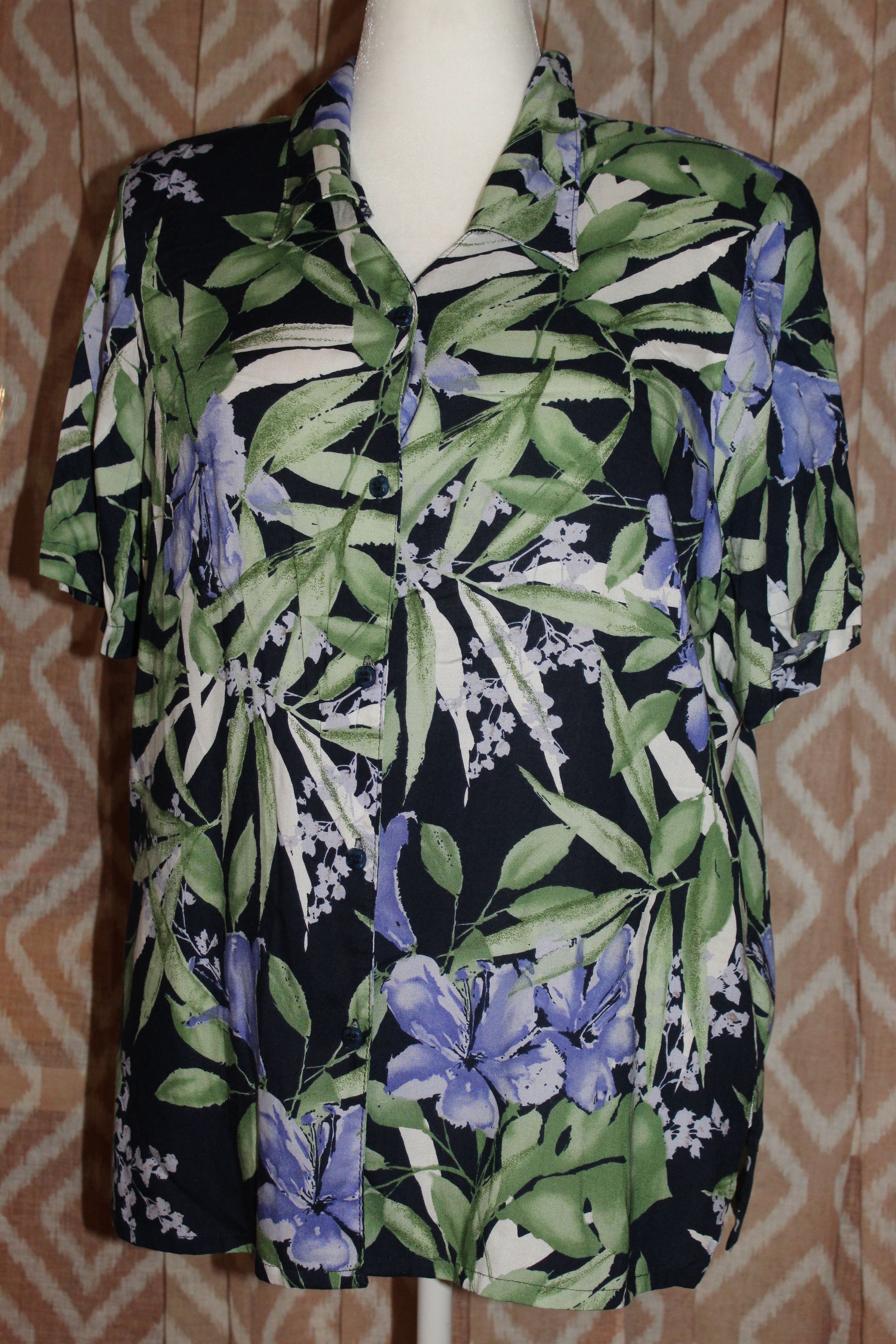 Black floral button-up shirt with green leaves and purple flowers on a mannequin