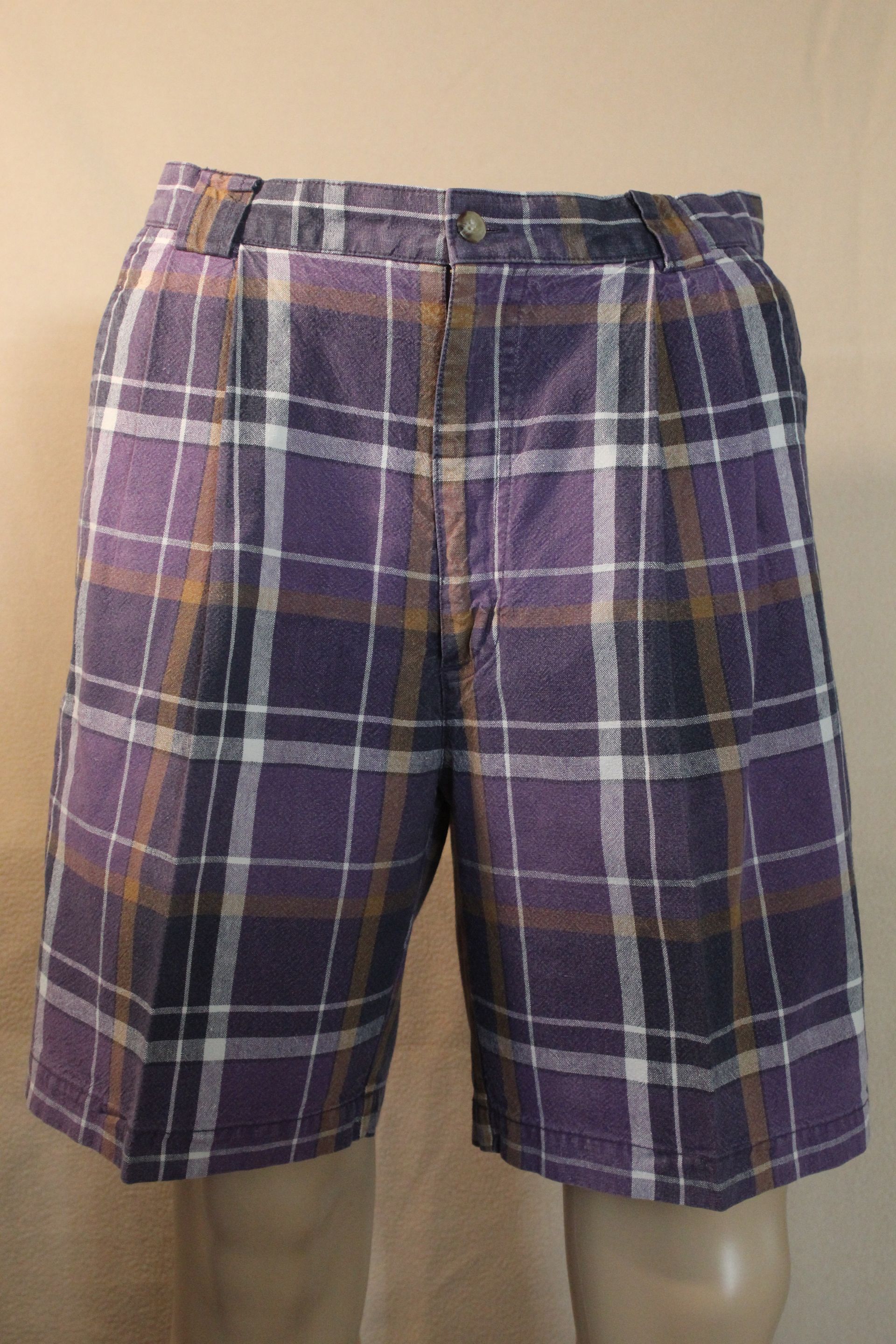 Purple plaid shorts with white and yellow stripes on a plain background