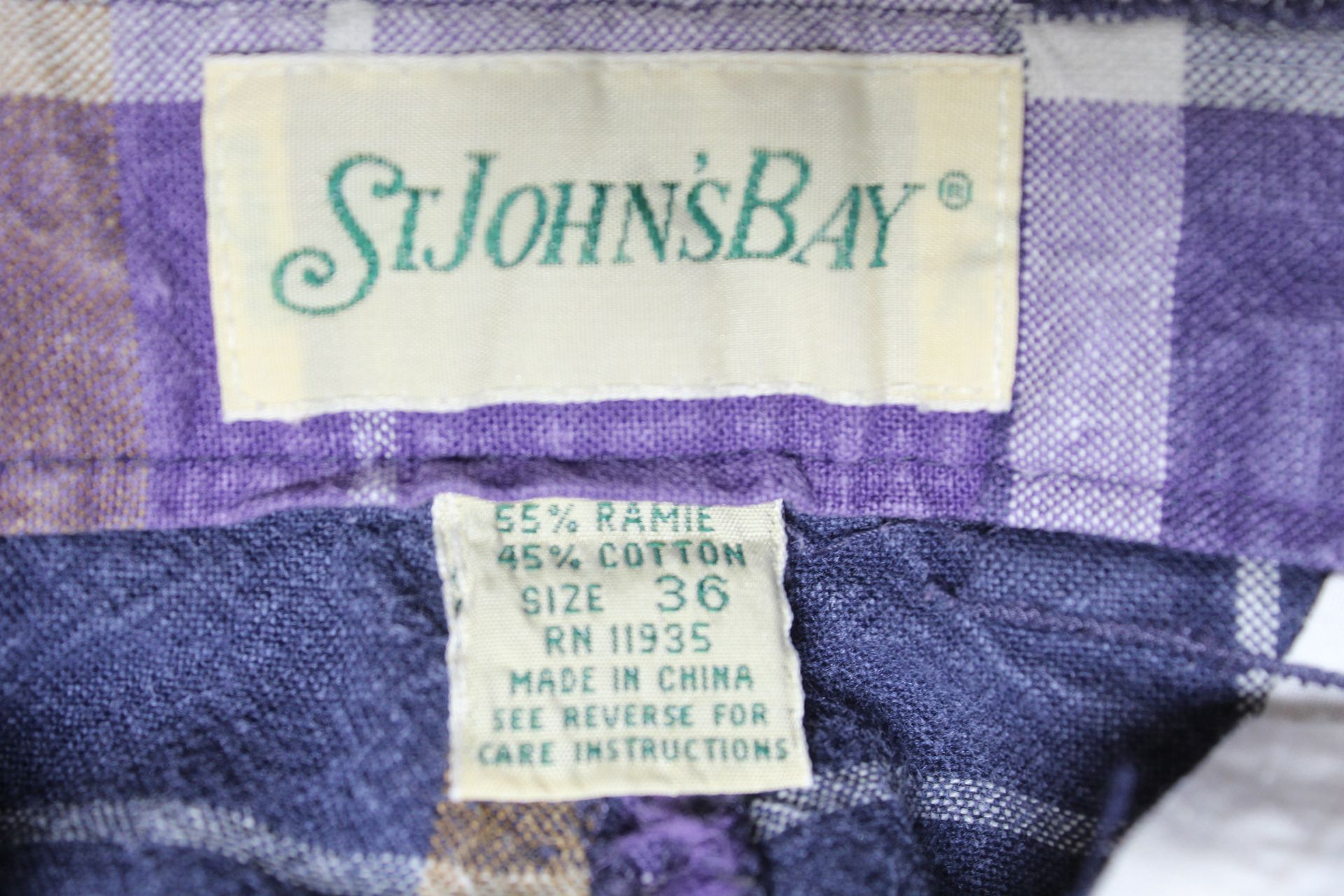 Purple plaid shorts with white and yellow stripes on a plain background