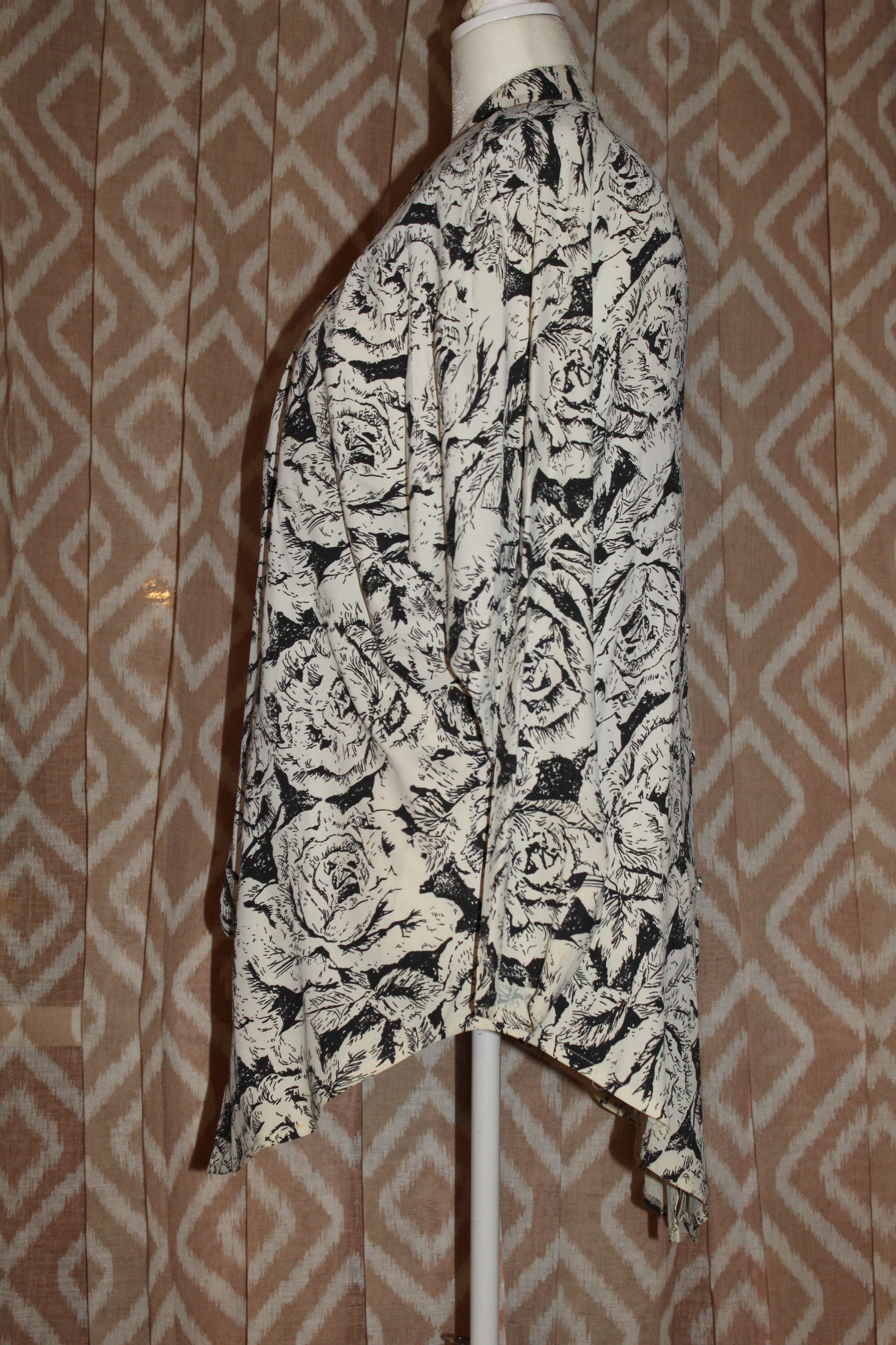 Black-and-white patterned garment hanging on a stand against a patterned curtain background
