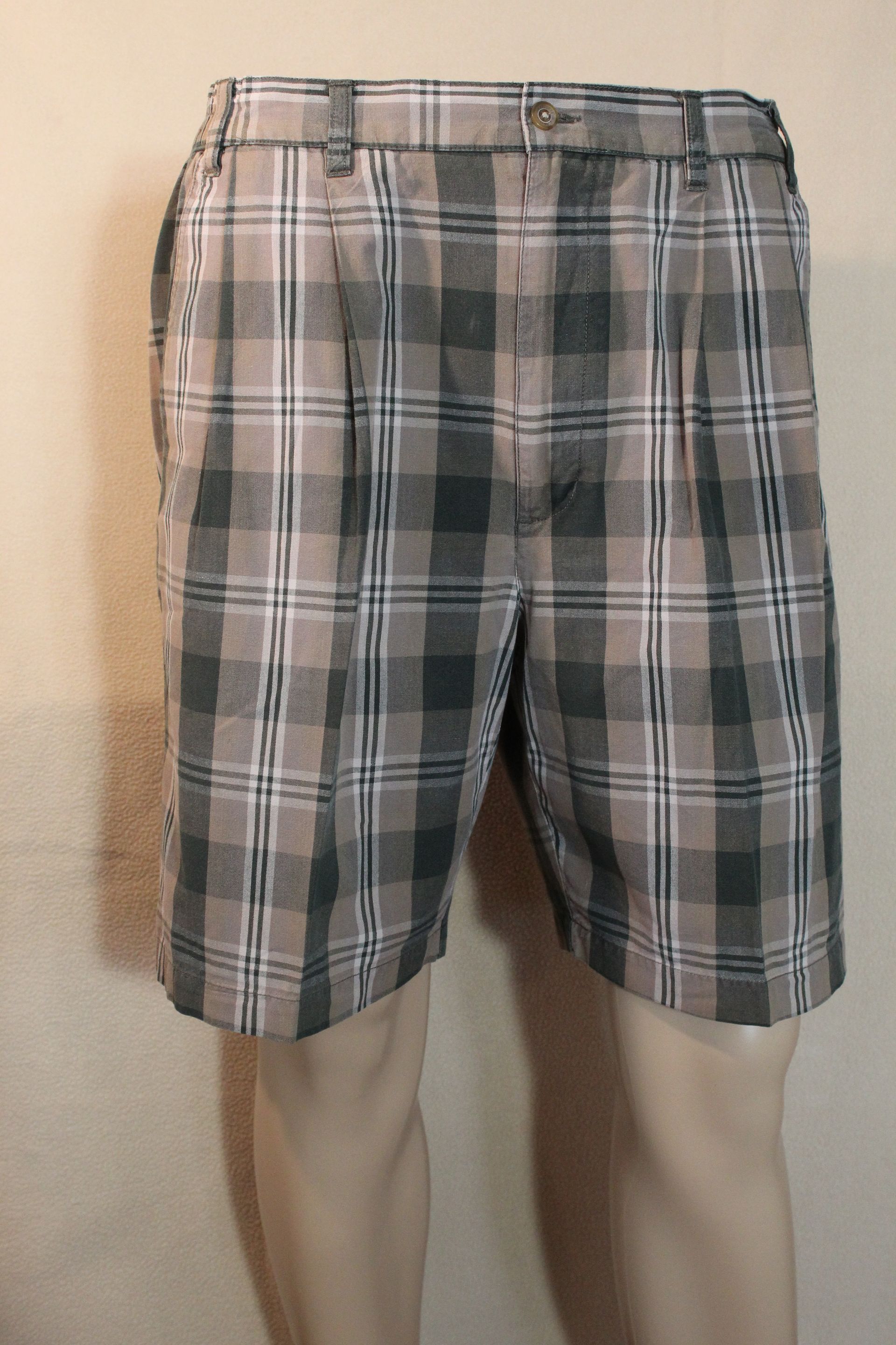 Plaid shorts on a mannequin against a plain wall.
