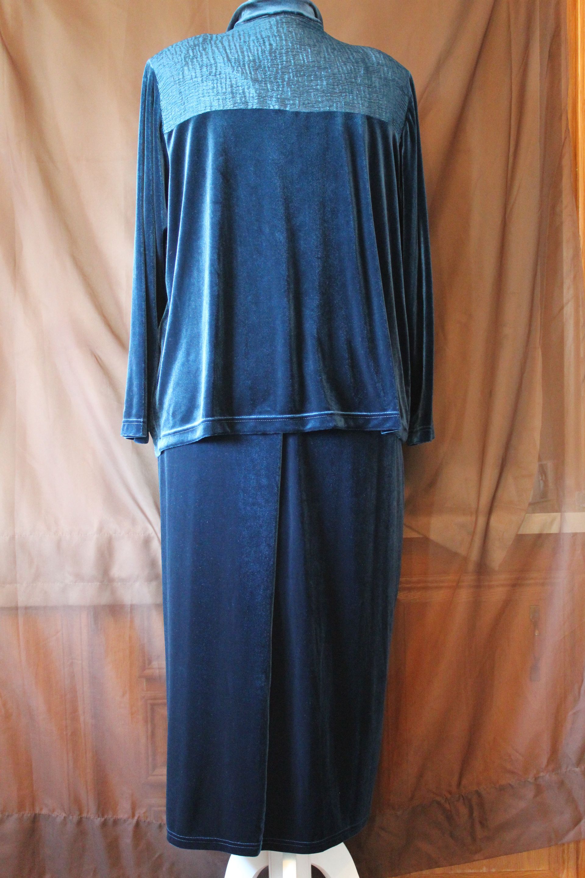 Blue velvet outfit displayed on a mannequin against a tan backdrop