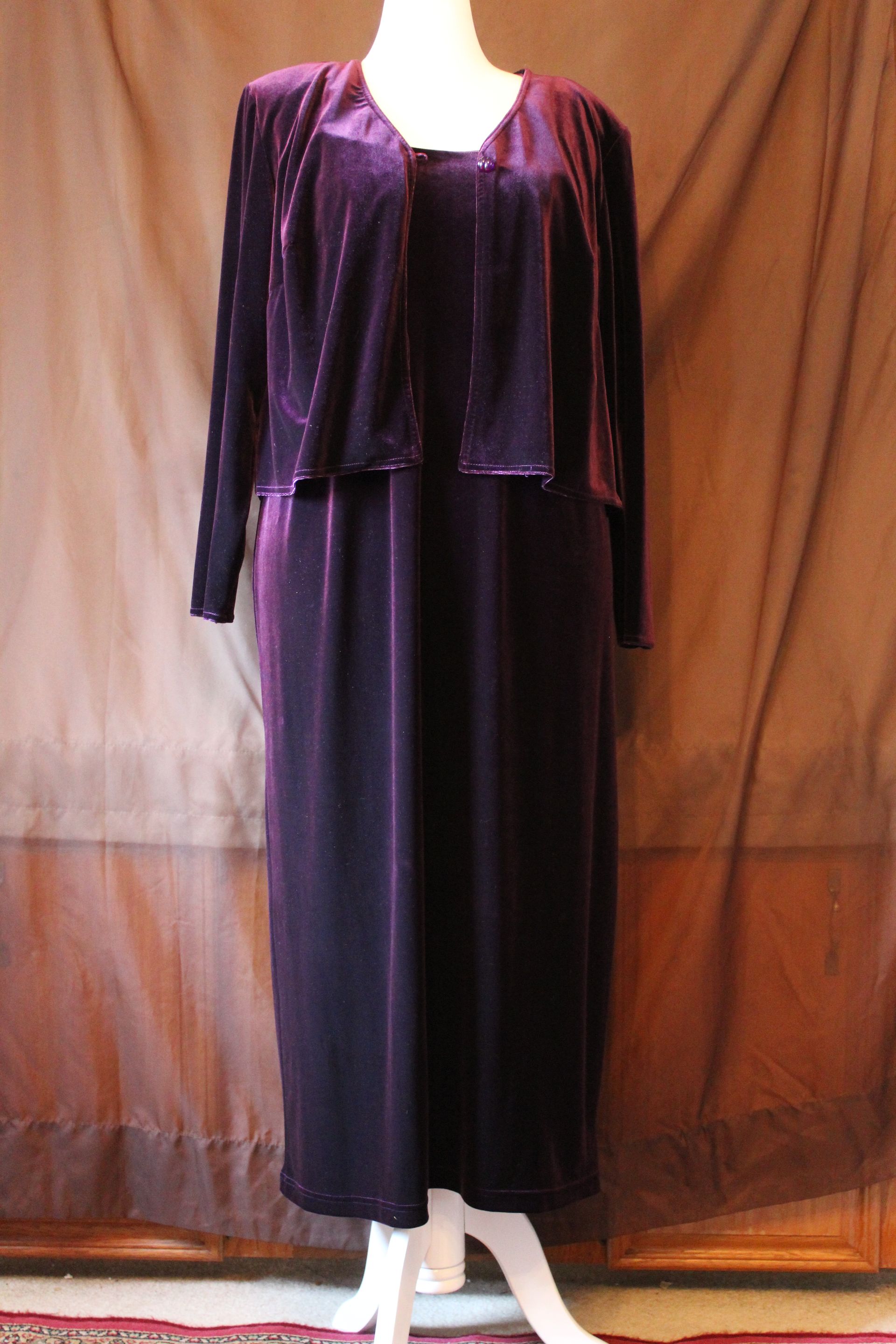 Purple long-sleeve dress on a mannequin against a brown backdrop