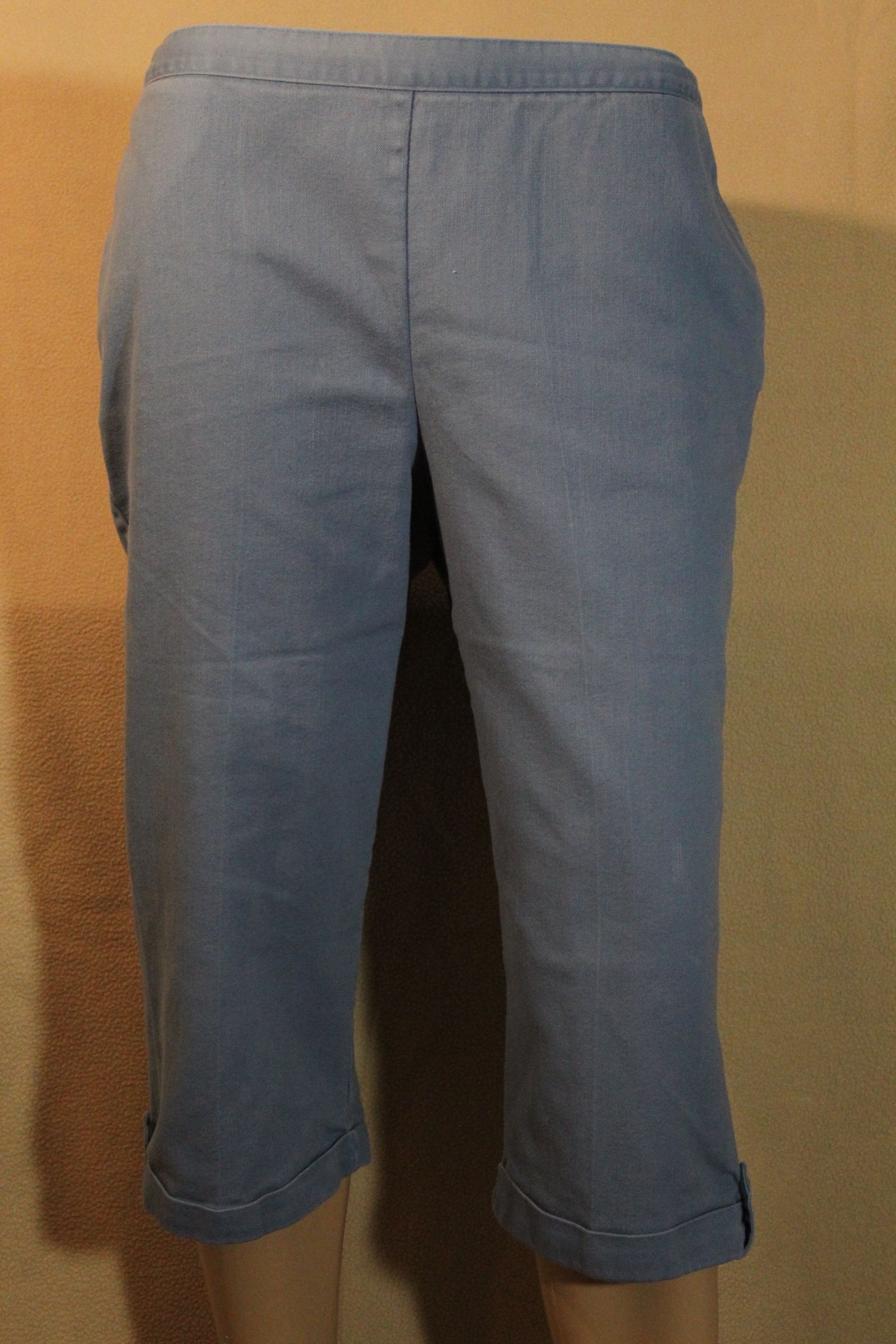 Blue-gray cropped pants displayed against a plain tan background.