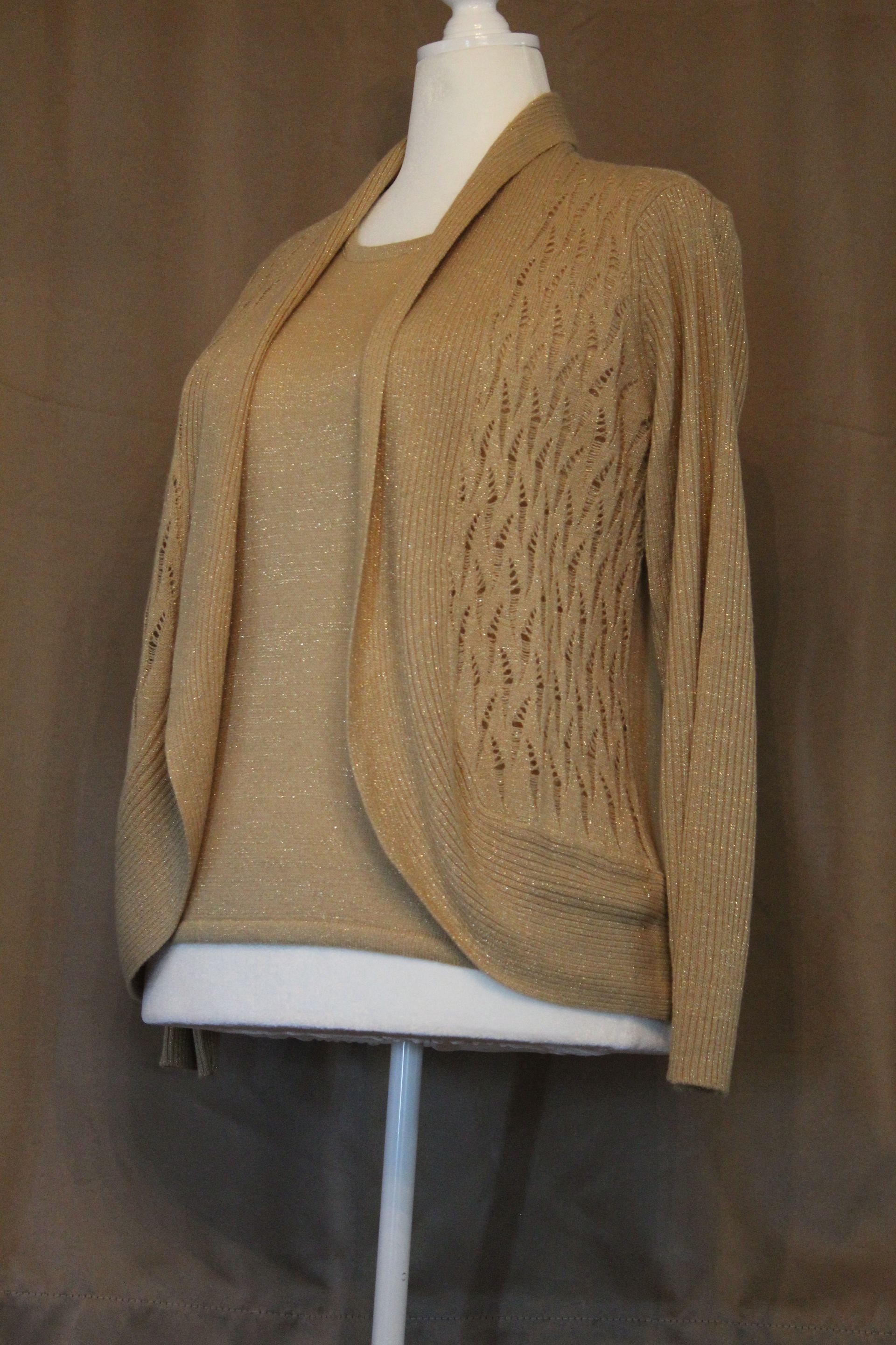 Tan textured beige cardigan on a dress form against a brown backdrop