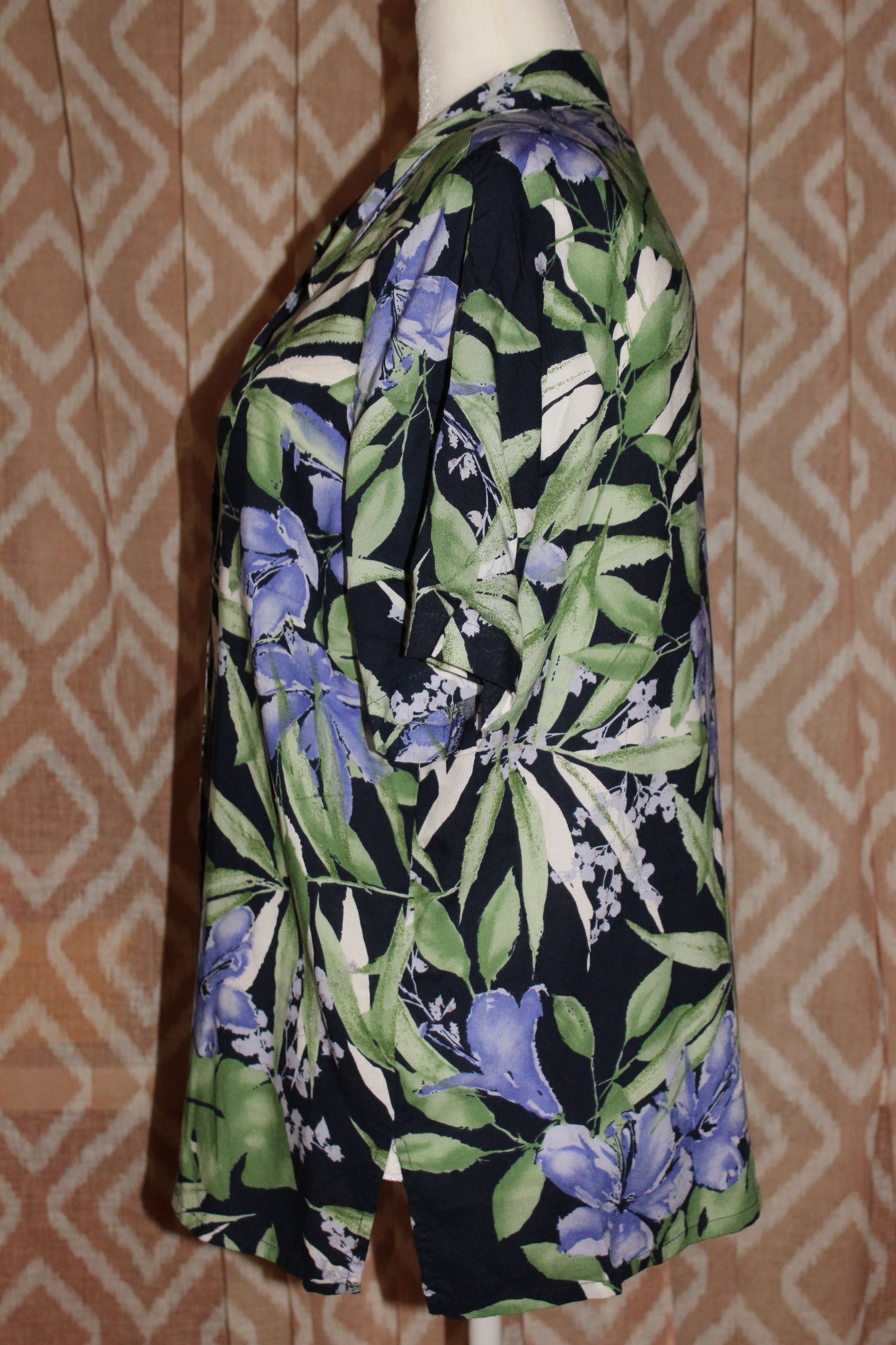 Black floral button-up shirt with green leaves and purple flowers on a mannequin