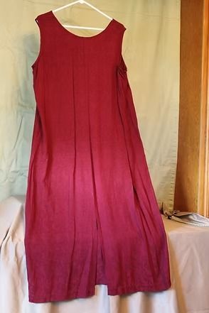 Red long-sleeve jacket and matching skirt on a mannequin against a tan backdrop.