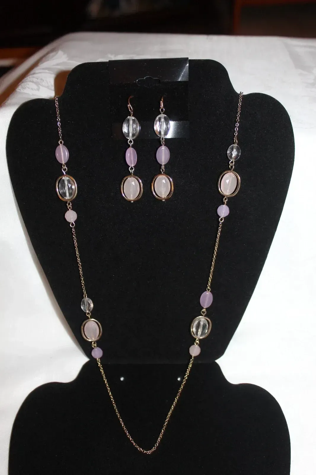 Black jewelry display bust with purple and silver necklace and matching earrings