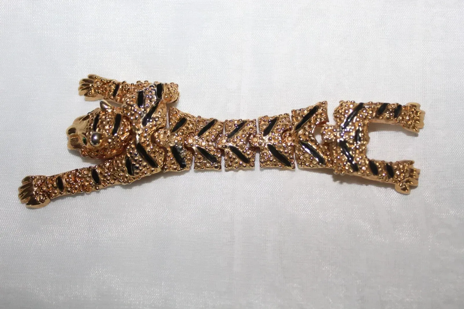Gold-and-black jeweled tiger-shaped hair clip on a white background