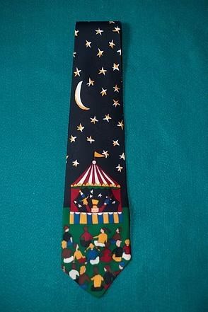 Night-themed necktie with stars, crescent moon, and a colorful carnival scene at the bottom.