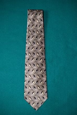 Silver patterned necktie on a teal background