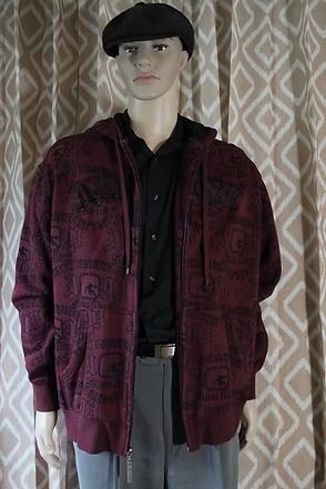 Mannequin wearing a black beret, dark shirt, and burgundy jacket against a patterned curtain.