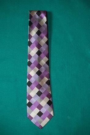 Purple and gray argyle necktie on a teal background
