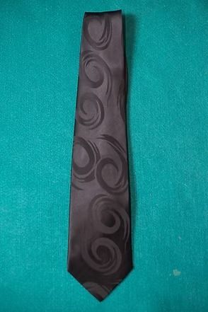 Black patterned necktie on a teal background