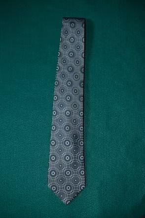 Gray patterned necktie on a green background