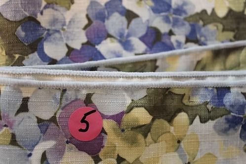 Pink numbered tag 5 on a floral fabric pouch with a white zipper