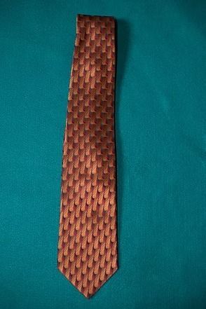 Copper patterned necktie on a teal background