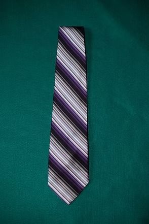 Purple, white, and black striped necktie on a teal background