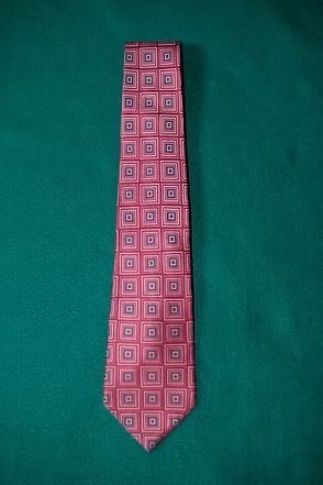 Pink patterned necktie on a green background