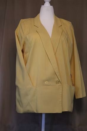 Yellow blazer jacket displayed on a mannequin against a dark background