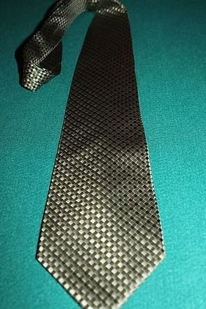 Black patterned necktie on a teal background
