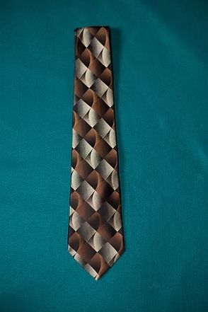 Brown patterned necktie on a teal background