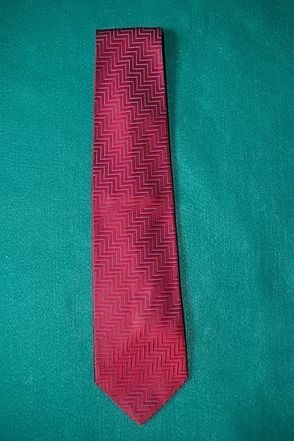 Red patterned necktie on a teal background