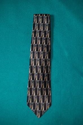 Black-and-gray patterned necktie on a teal background