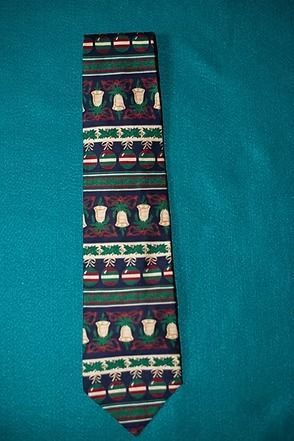 Patterned necktie with colorful horizontal stripes and tassel-like motifs on a teal background