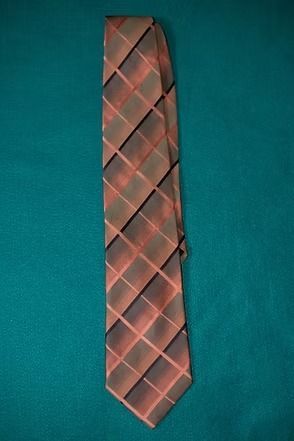 Pink and gray plaid necktie on a teal background