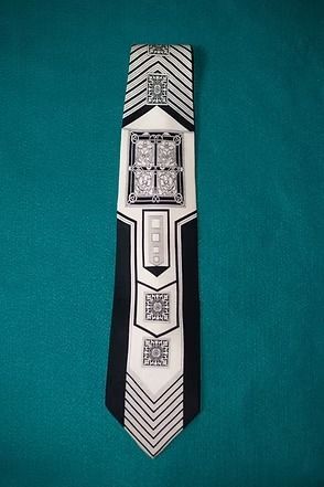 Black-and-white geometric necktie on a teal background