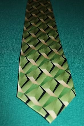 Green patterned necktie on a teal background