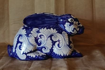 Blue-and-white ceramic rabbit figurine on a wooden surface