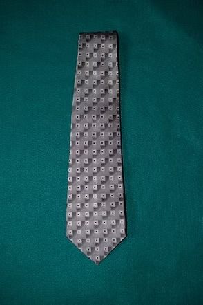 Gray patterned necktie on a green background