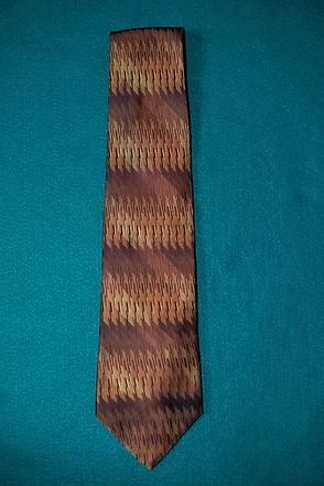 Brown patterned necktie on a teal background