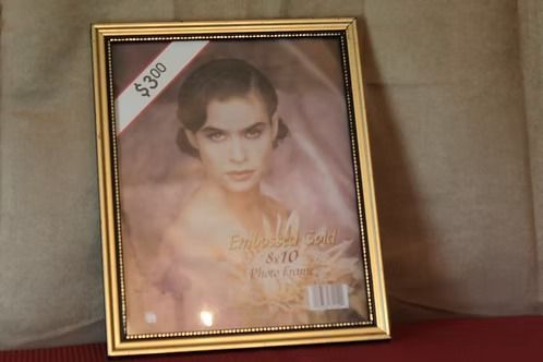 Framed portrait print of a woman with a price tag in the corner, leaning against a wall