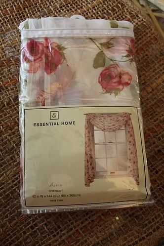 Folded floral sheer curtain package in white and pink with product label and window photo