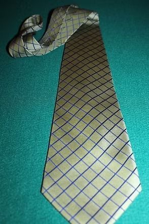 Yellow tie with blue and brown diamond pattern on teal background