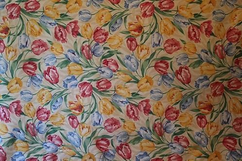 Colorful floral fabric with pink, red, yellow, and blue leaves and flowers