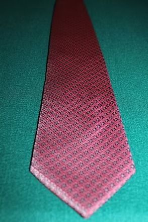 Red patterned necktie on a green background