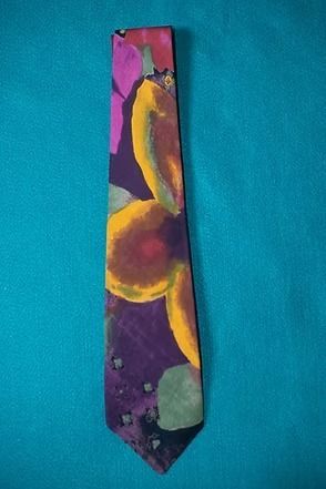 Colorful patterned necktie on a teal background