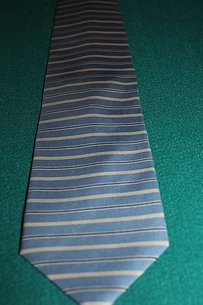 Blue striped necktie on a green surface
