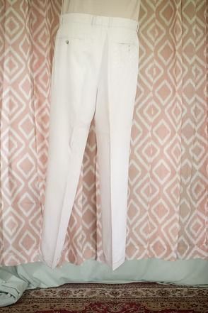 White curtains hanging in front of pink patterned drapes over a rug-covered floor