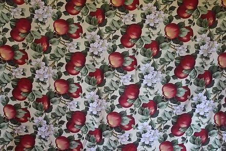 Floral red apple-patterned fabric with white flowers and green leaves