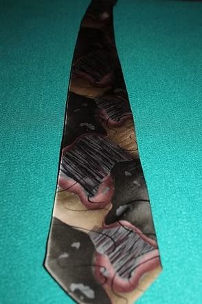 Necktie with camouflage pattern on a teal fabric background