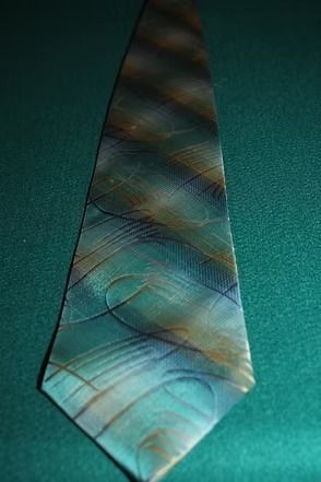 A blue-green striped necktie on a teal textured background.