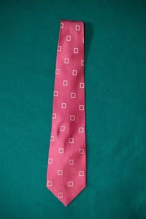 Pink patterned necktie on a green background